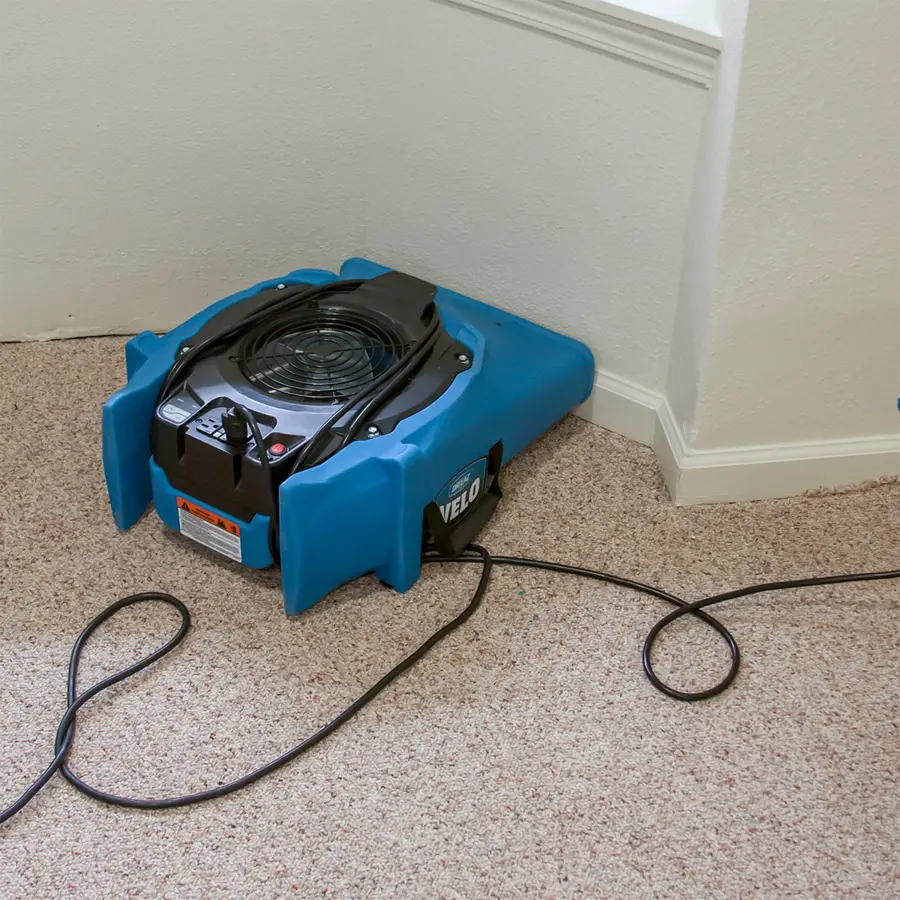 Restoration technician drying a floor in a Bedford, TX home